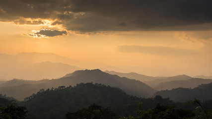 Fototapeta premium Sunset at the mountain landscape, the sun behind clouds