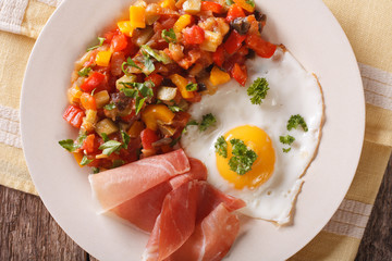 Spanish breakfast: fried egg, ham and pesto on the table. horizontal top view
