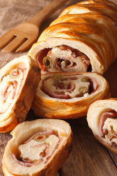 sliced bread stuffed with ham and olives close-up vertical
