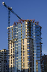 Fototapeta na wymiar Construction crane on the high-rise building