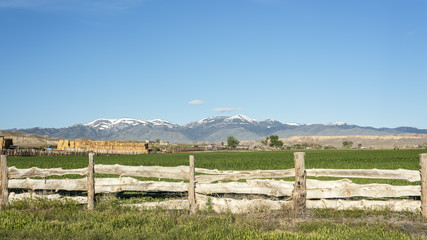 Fototapeta na wymiar Custom wood fence and snow covered Idaho mountains