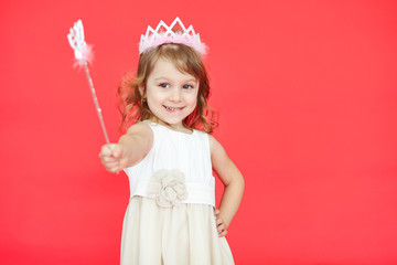 Little princess girl pointing her magic wand towards camera