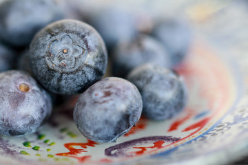 Heidelbeeren auf buntem Teller auf Schieferplatte