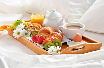 Breakfast tray in bed in hotel room
