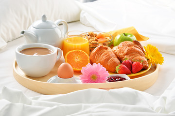 Breakfast tray in bed in hotel room