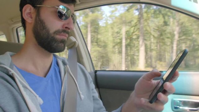 Man illegally uses his phone to text while he is driving 