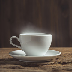 white coffee cup with smoke on wood table