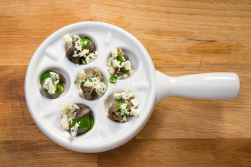 Snails with pesto sauce and blue cheese.