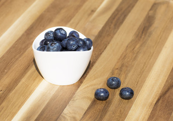 Dessert fresh berries in the bowl. Blueberries on a wooden table. Dessert, fresh berries close-up. 