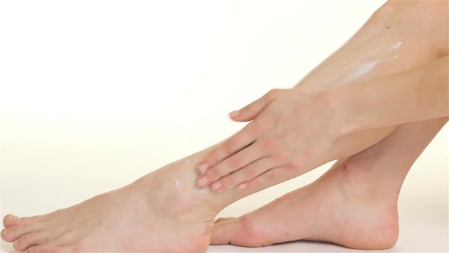 Close up of woman creams her leg
