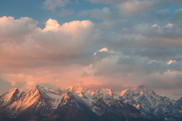 Beautiful clouds illuminated by the rising sun over High Tatra mountains covered with snow, Poland