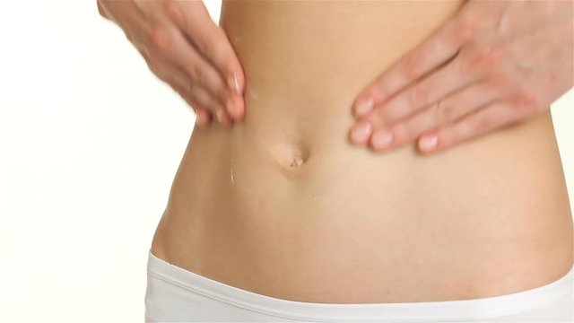 Close up of woman creams her belly