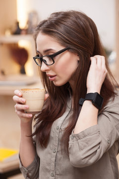 Beautiful girl is enjoying hot beverage