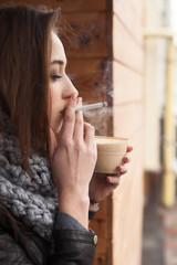 Attractive girl is enjoying latte outside