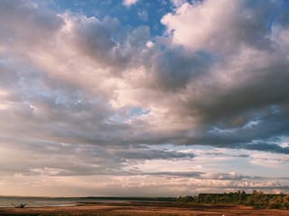 Безмятежное пространство с красивыми пушистыми облаками в голубом небе на заброшенном необитаемом острове