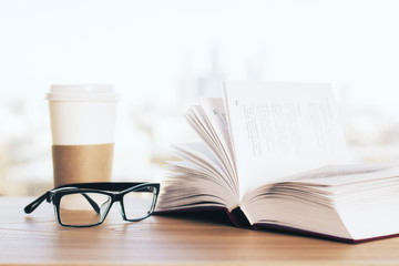 Open book, coffee and glasses