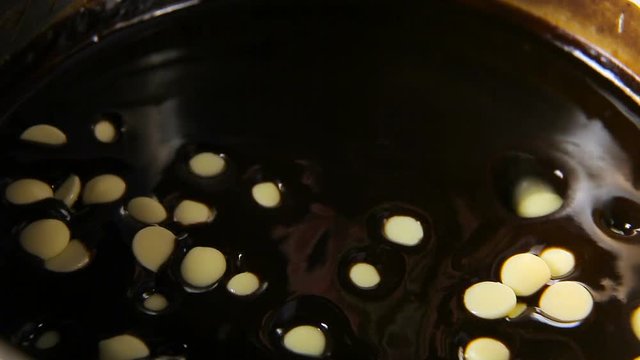 White chocolate mugs fall into a metal pan