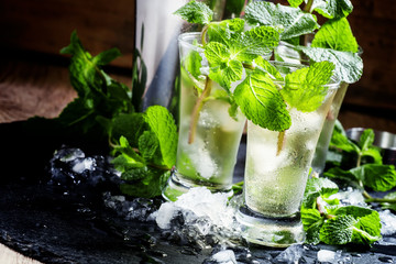 Green tea with ice, mint and white rum, dark background, selecti