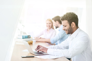 Cheerful male student is working on computer
