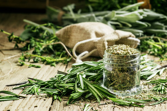 Dried rosemary in a glass jar, branches of fresh rosemary, vinta