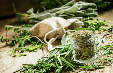 Dried rosemary in a glass jar, branches of fresh rosemary, vinta