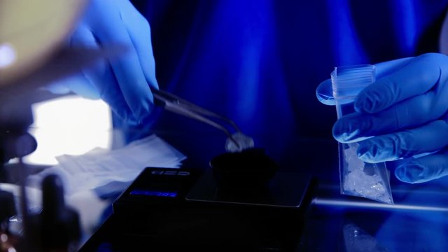 Scene moves down from boiling substance to meth being carefully placed into small clear bags.