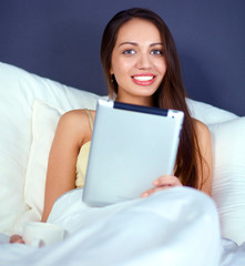 Obraz na płótnie Canvas Women use a tablet pc on the bed