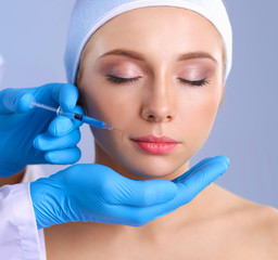 Cosmetic injection on the pretty woman face. Isolated on gray background