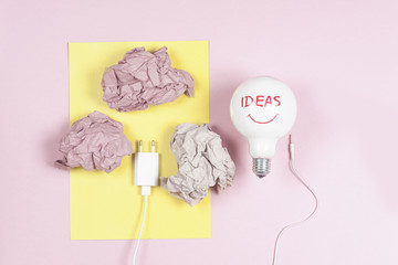 great idea concept with crumpled colorful paper and light bulb on light background. Creative brainstorm concept business idea.  female hand holding light bulb.