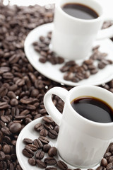 two coffee cups with coffee beans.