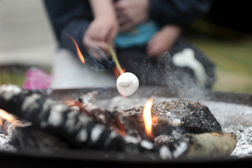 Roasting marshmallows over an open camp fire
