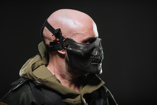  soldier military man in a black mask on a dark background.