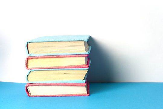 Stack of colorful books, grungy blue background, free copy space. Education essential for self improvement, gaining knowledge and success in our careers, business and personal lives.