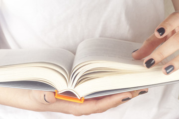 Young girl reading an  open book  old book. Books and reading are essential for self improvement, gaining knowledge and success in our careers, business and personal lives.