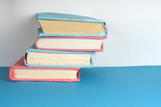 Stack of colorful books, grungy blue background, free copy space. Education essential for self improvement, gaining knowledge and success in our careers, business and personal lives.