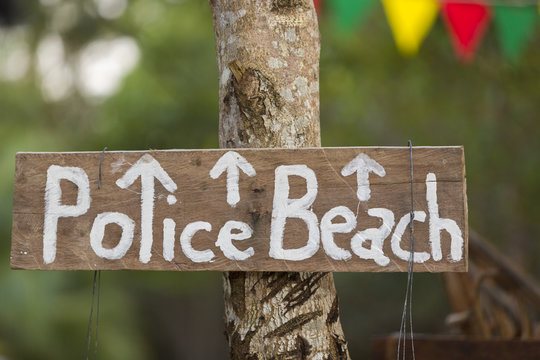 Police beach wooden sign hanging on a tree on Koh Rong Island