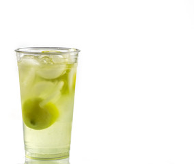 Fresh squeezed lemonade in a clear cup with lemons and ice.