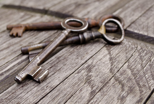 Vintage keys on old wooden background. Close-up. Three old, rustic keys on the table