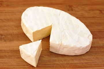 Cheese camembert on the brown wooden background