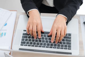 Closeup of business woman hand typing on laptop keyboard