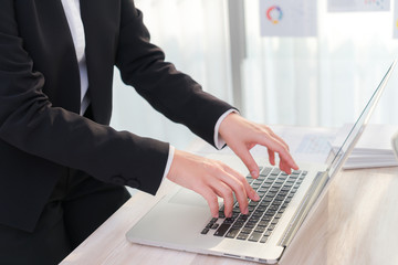 Closeup of business woman hand typing on laptop keyboard