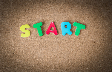 Colorful Wooden word START on cork board