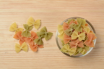 Pasta farfalle en un bol de cristal sobre fondo de madera