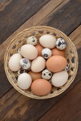 Overhead view of mix eggs in the basket on wooden table