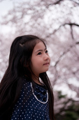 桜の咲く公園で微笑む日本人の女の子