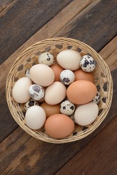 Overhead view of mix eggs in the basket on wooden table
