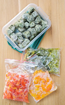 Frozen Vegetables On Cutting Board And Plastic Bags. Top View