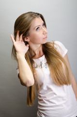 Young woman surprised trying to hearing something