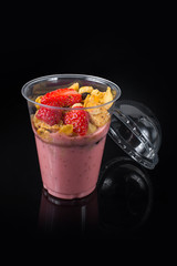 Chia Pudding with Strawberry in plastic cup on Black