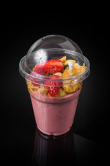 Chia Pudding with Strawberry in plastic cup on Black